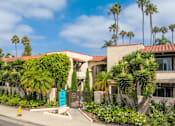 Thumbnail 3 of 25 - A building with a blue sign in front of it.