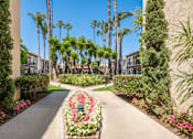 Thumbnail 4 of 25 - A garden pathway with a flower bed in the middle.
