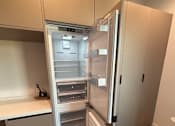 Thumbnail 15 of 29 - A white refrigerator with its door open in a kitchen.