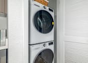 Thumbnail 16 of 29 - Two washing machines stacked on top of each other in a laundry room.