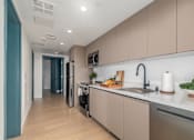Thumbnail 23 of 29 - A modern kitchen with a refrigerator, oven, and sink.