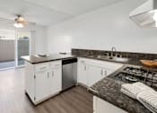 Thumbnail 10 of 23 - Updated kitchen with granite countertops, white cabinetry, and dining nook in Tustin.
