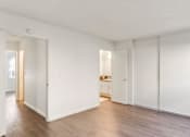 Thumbnail 3 of 23 - White bedroom with wood-look floors and ceiling fan at Arbor Ranch Apartments