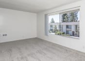 Thumbnail 12 of 14 - an empty living room with a large window and carpet