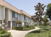 Thumbnail 9 of 14 - a row of apartments with gardens and trees in front of them