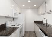 Thumbnail 13 of 14 - a kitchen with white appliances and granite counter tops and white cabinets