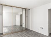 Thumbnail 11 of 14 - an empty room with white walls and mirrored closet doors