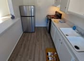 Thumbnail 14 of 24 - a small kitchen with a sink and a refrigerator