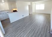 Thumbnail 13 of 24 - an empty living room with a kitchen in the background