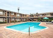 Thumbnail 2 of 32 - A swimming pool in front of apartment buildings.