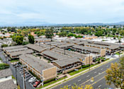 Thumbnail 3 of 32 - A view of a residential area with apartment buildings and cars parked on the street.