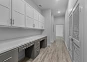 Thumbnail 25 of 38 - A kitchen with white cabinets and a wooden floor. at The Quarter Lofts Apartments, Jackson, Mississippi