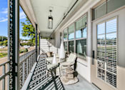 Thumbnail 9 of 38 - A balcony with a table and chairs and a lamp. at The Quarter Lofts Apartments, Jackson, MS
