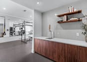 Thumbnail 21 of 38 - A modern kitchen with wooden cabinets and a white countertop. at The Quarter Lofts Apartments, Mississippi, 39216