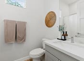 Thumbnail 31 of 31 - a bathroom with a toilet and a sink and a mirror at Village of Chandler Apartments, Arizona, 85249
