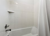 Thumbnail 30 of 31 - a bathroom with a tub and a shower curtain at Village of Chandler Apartments, Chandler, Arizona