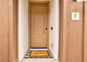 Thumbnail 7 of 31 - the front door of a building with a door way with a sign that says village at Village of Chandler Apartments, Chandler, Arizona