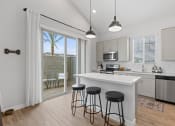 Thumbnail 19 of 31 - an open kitchen with a island and three stools at Village of Chandler Apartments, Chandler