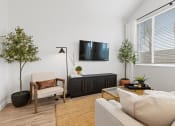 Thumbnail 11 of 31 - a living room with a couch and a tv on the wall at Village of Chandler Apartments, Chandler, AZ, 85249