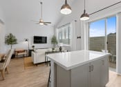 Thumbnail 21 of 31 - a kitchen island in a living room with a couch and a tv at Village of Chandler Apartments, Arizona, 85249