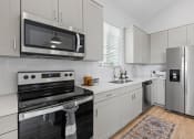 Thumbnail 18 of 31 - a kitchen with stainless steel appliances and white cabinets at Village of Chandler Apartments, Chandler, 85249