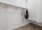Thumbnail 27 of 31 - a white room with clothes hanging on a rack and a white curtain at Village of Chandler Apartments, Arizona