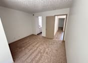 Thumbnail 19 of 50 - A room with a carpeted floor and a door leading to another room.