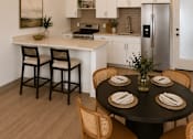 Thumbnail 8 of 10 - A modern kitchen with a dining table set for four.
