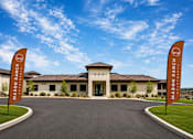 Thumbnail 3 of 10 - The entrance to Mason Ranch Resort with two flags on either side.