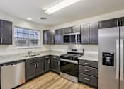 Thumbnail 5 of 48 - A kitchen with dark wood cabinets and stainless steel appliances.