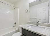 Thumbnail 10 of 48 - A white bathroom with a toilet, sink, and shower.