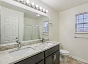 Thumbnail 9 of 48 - A bathroom with a marble countertop and a white toilet.
