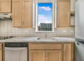 Thumbnail 6 of 10 - a kitchen with wooden cabinets and a window over the sink