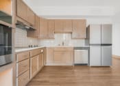 Thumbnail 4 of 10 - a kitchen with wooden cabinets and stainless steel appliances