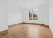 Thumbnail 5 of 10 - a room with white walls and wood floors and a large window