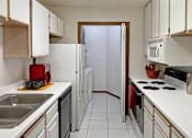 Thumbnail 31 of 44 - A kitchen with white cabinets and a white counter top.
