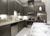 Thumbnail 1 of 45 - Luxury apartments with spacious kitchens with granite countertops, large granite slab island, built-in wine rack, and stainless appliances at Le Palais Apartments in Houston.