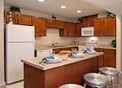 Thumbnail 6 of 27 - Apartments with upgraded kitchen, chestnut-colored cabinets, kitchen island, breakfast bar, lots of cabinet space, lots of counter space at Alpine Village Apartments in La Vista, Nebraska