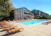 Thumbnail 1 of 35 - Huge swimming pool with spacious sundeck, poolside lounge chairs, beautiful landscaping, and scenic views at LionsHead Apartments in Omaha, Nebraska