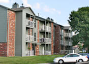 Thumbnail 3 of 35 - Green and red brick exterior, beautiful landscaping, scenic views, lots of trees, and spacious balconies at LionsHead Apartments in Omaha, Nebraska