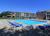 Thumbnail 18 of 25 - Huge swimming pool with spacious sundeck, poolside lounge chairs, beautiful landscaping, and scenic views at LionsGate Apartments in Lincoln, Nebraska