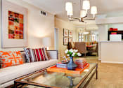 Thumbnail 13 of 36 - Spacious living room with built-in bookshelves, crown molding, dining room with mirrored accent walls, 9-foot ceilings, and breakfast bar at Tuscany Apartments in Houston.