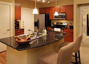 Thumbnail 26 of 29 - Luxury apartments with hardwood floors, granite countertops, stainless steel appliances, and honey-brown toned cabinets in the Las Colinas area of Irving, Texas