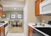 Thumbnail 29 of 73 - Luxury apartments with kitchens featuring honey brown toned cabinets, ample cabinet and countertop space, and spacious dining room area at Saxony Apartments in Dallas
