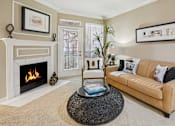 Thumbnail 37 of 73 - Spacious living room with wood-burning fireplace, French door, and crown molding at The Saxony Apartments in Dallas