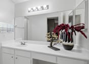 Thumbnail 26 of 42 - A white bathroom with a sink, mirror, and vase.