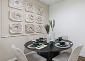 Thumbnail 24 of 42 - A dining table set with plates and glasses is surrounded by chairs.