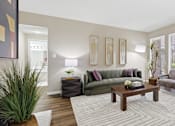 Thumbnail 14 of 42 - A living room with a couch, a coffee table, and a potted plant.