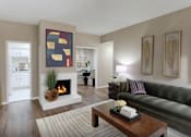 Thumbnail 23 of 42 - A living room with a fireplace and a painting on the wall.