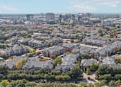 Thumbnail 61 of 73 - Aerial view of Saxony Apartments with view of downtown Dallas skyline and neighborhood with lots of trees
